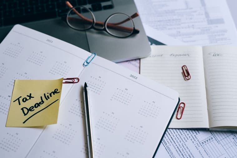 A desk planner with a tax deadline marked on a sticky note