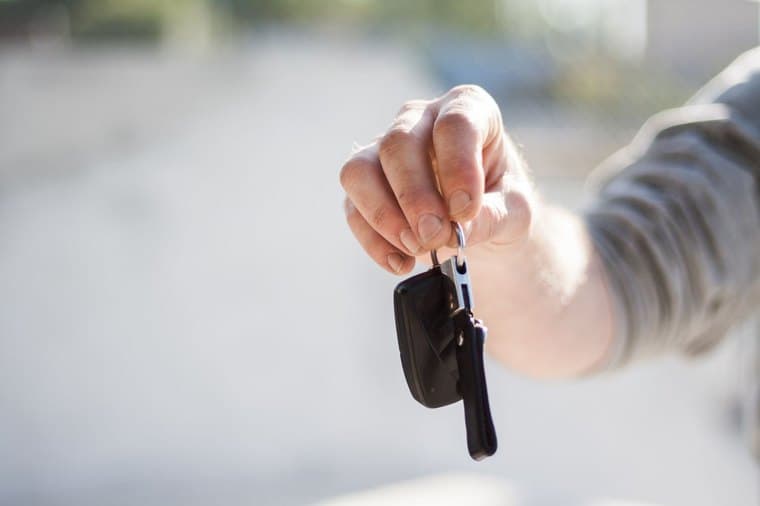 Handing over car keys, representing the choice of how to finance a car