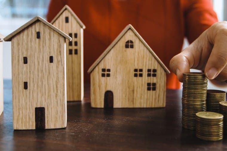 Model houses and stacked coins, representing home loan savings